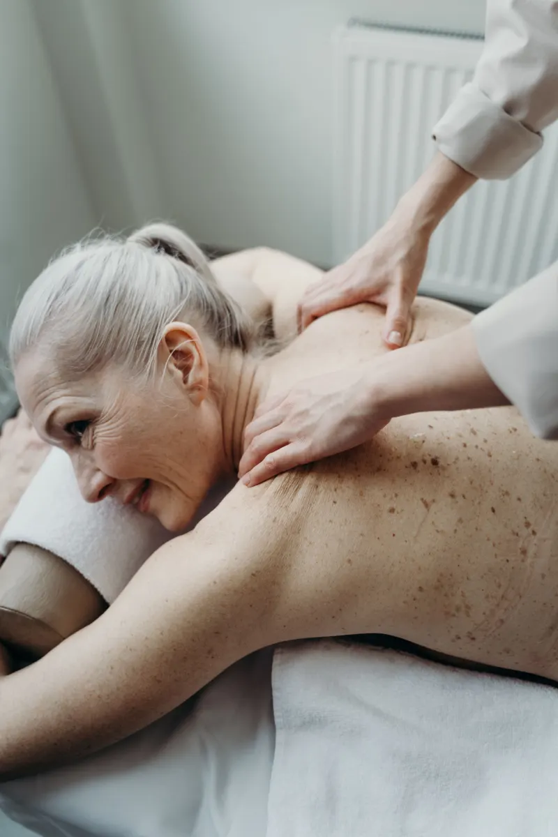 An older client relaxing during a shoulder massage