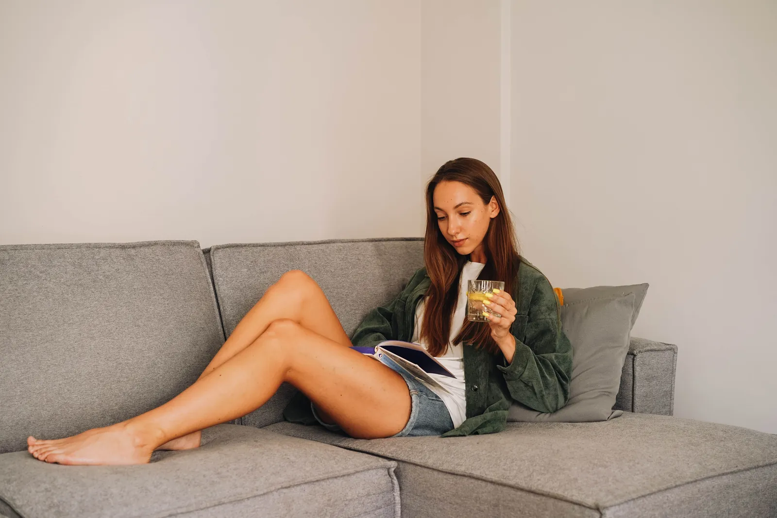 Woman resting on a sofa with a glass of water after a massage